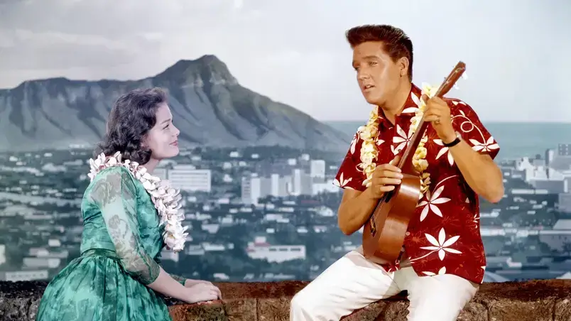 Cena do filme Blue Hawaii onde Elvis está tocando ukulele para uma mulher